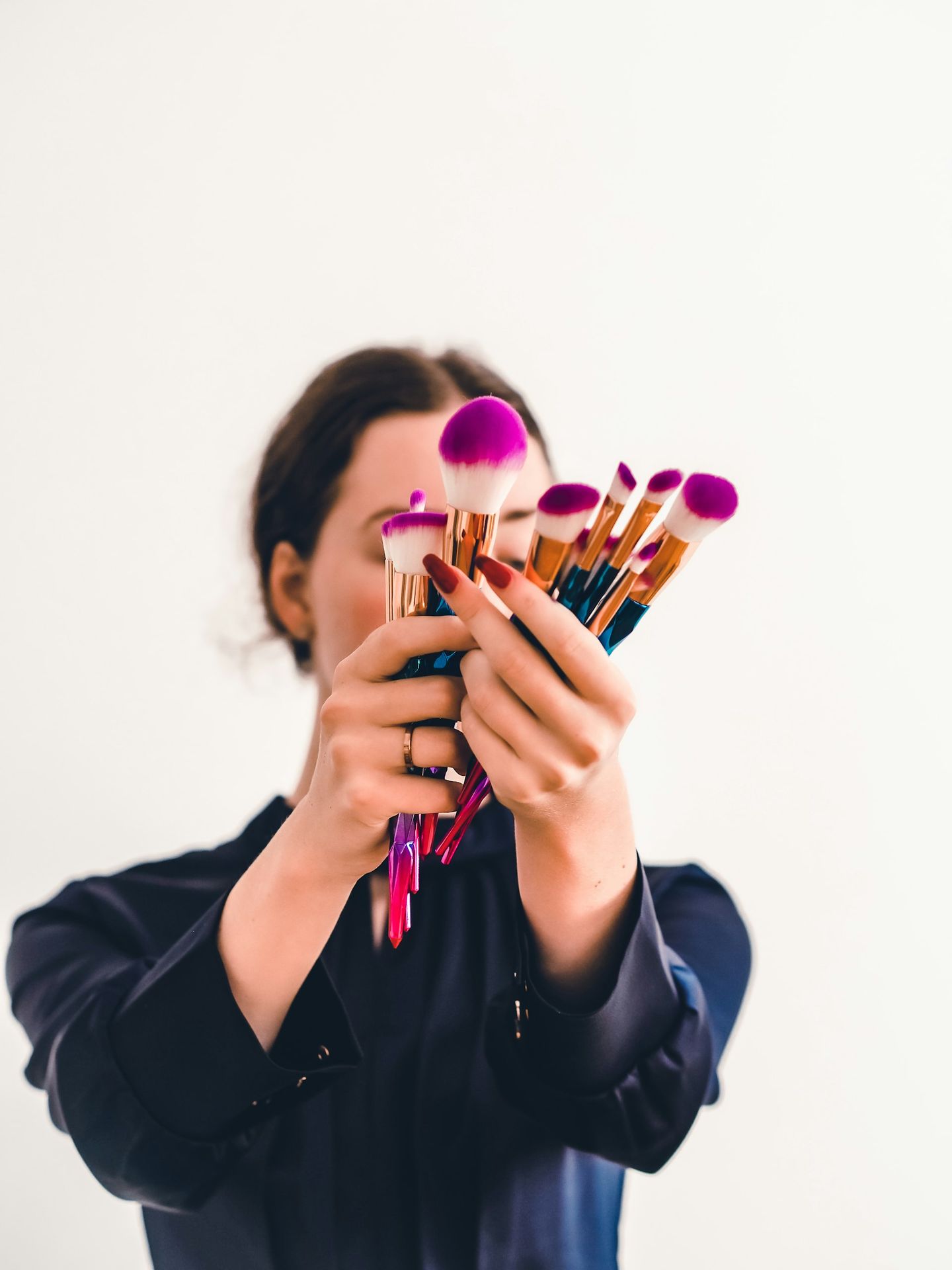 woman in black jacket holding makeup brush